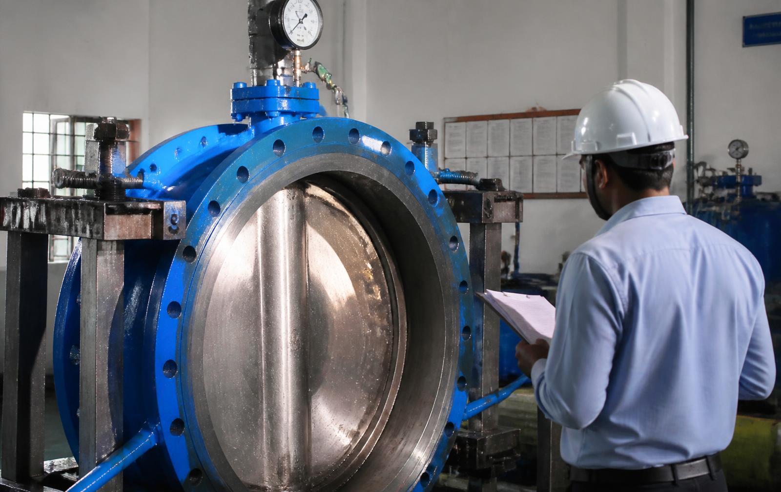 Large butterfly valve under hydrostatic pressure test with QC inspector